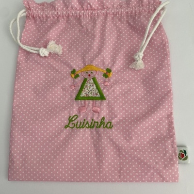Saco de pano rosa com bolinhas brancas e bordado de boneca, nome Luisinha