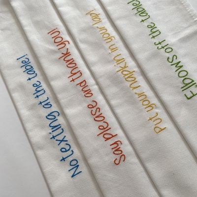 Panose brancos bordados com frases em cores diferentes