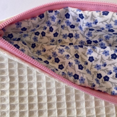 Bolsa branca com fecho rosa e interior floral azul