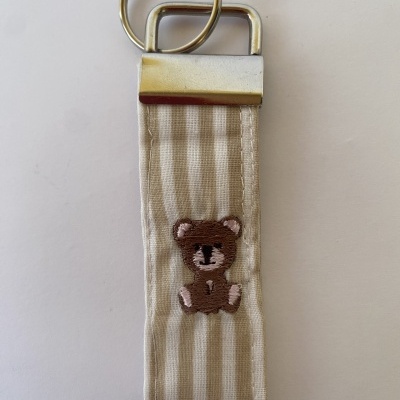 Chaveiro de tecido riscas branco e bege com ursinho bordado e argola metálica