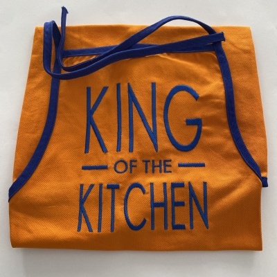 Avental laranja com bordas azul e texto 'KING OF THE KITCHEN'