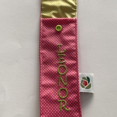 Estojo tecido rosa com bolinhas brancas e nome LEONOR bordado a verde.
