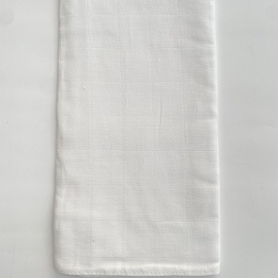 Toalha de tecido branca dobrada com padrão de quadrados sutis