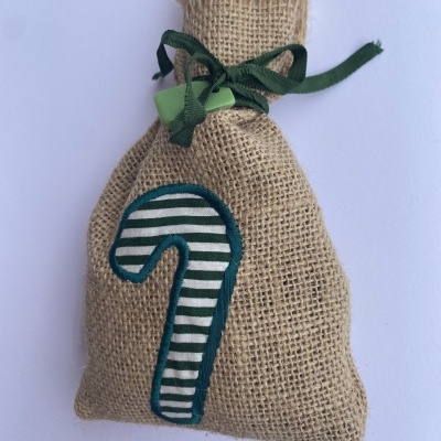 Saco de juta com laço verde e bordado de bastão de doces verde e branco