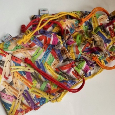 Sacos de tecido coloridos com padrão de molas de roupa e cordões coloridos