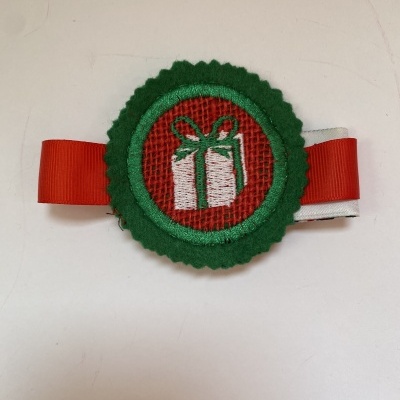 Presilha decorativa com laço vermelho e branco e aplique redondo com bordado de presente