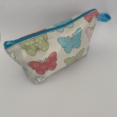 Bolsa pequena com padrão de borboletas coloridas e fecho azul