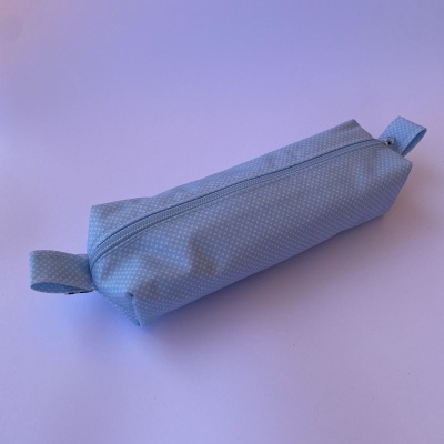 Estojo azul claro com padrão de pontos brancos e fecho de correr