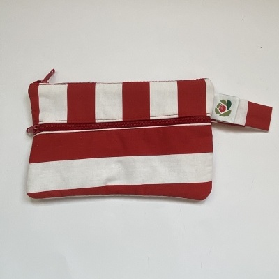 Bolsa pequena de tecido riscada em vermelho e branco com fecho e etiqueta lateral