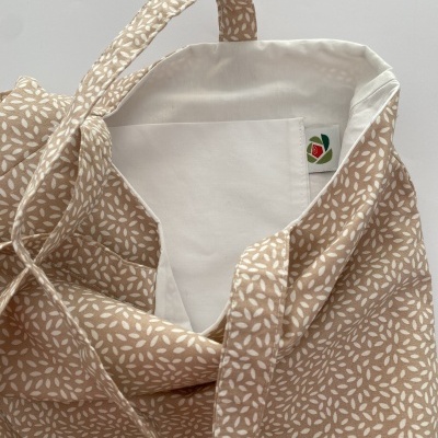 Saco de tecido bege com padrão branco e interior forrado branco