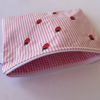 Bolsa rosa às riscas com morangos bordados e fecho branco aberta