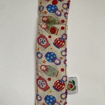 Estojo tecido com padrão de bonecas russas coloridas e botão vermelho