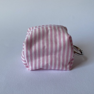 Bolsa pequena rosa às riscas com argola prateada sobre fundo branco