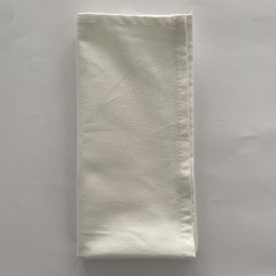 Guardanapo de tecido branco dobrado sobre superfície branca