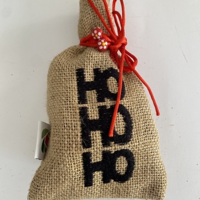 Saco de juta com cordão vermelho e texto HO HO HO
