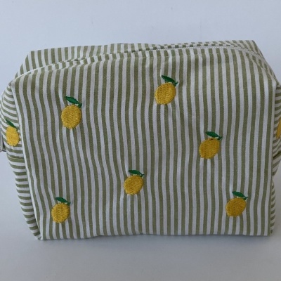 Necessaire de tecido com padrão riscado verde e branco e bordados de limões