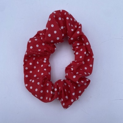 Elástico de cabelo vermelho com bolas brancas sobre fundo branco