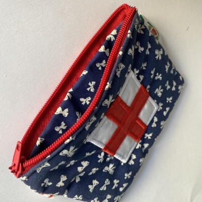 Necessaire azul com padrão de laços brancos e fecho vermelho