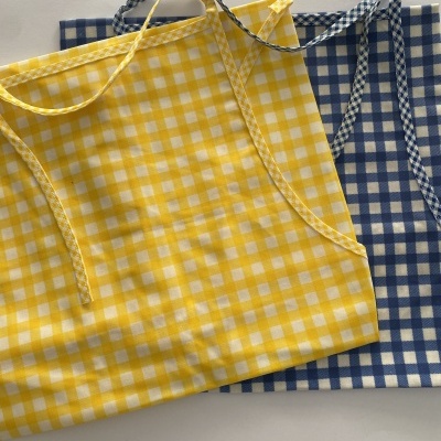 Dois aventais xadrez amarelo e azul com alças trançadas