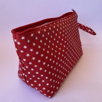 Necessaire vermelha com estrelas brancas e fecho vermelho