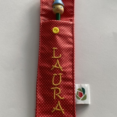 Estojo vermelho com pontos brancos e lápis com personagem de madeira