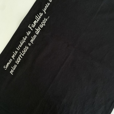 Pano preto com bordado branco com texto em português.