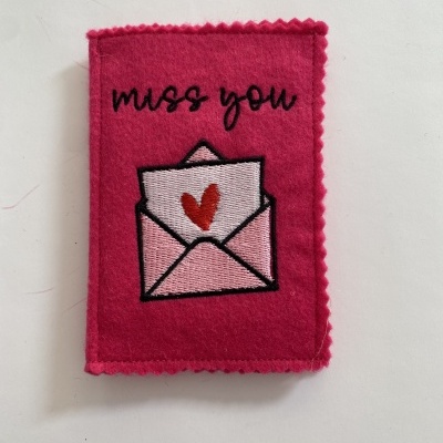 Caixa de feltro rosa com bordado 'miss you' e envelope com coração