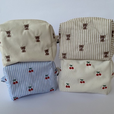 Quatro necessaires tecido com fecho, padrão ursinhos e cerejas, fundos bege, bege às riscas, azul às riscas e creme.