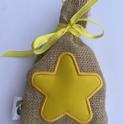Saco pequeno de tecido tipo juta com estrela amarela bordada e fita amarela.