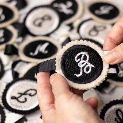 Fitas de cetim com bordados circulares a preto e branco com letras bordadas em branco