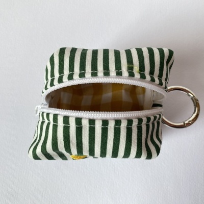 Bolsa de tecido pequena verde às riscas com fecho branco e argola metálica