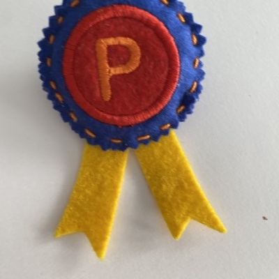 Broche de feltro com letras e fitas amarelas