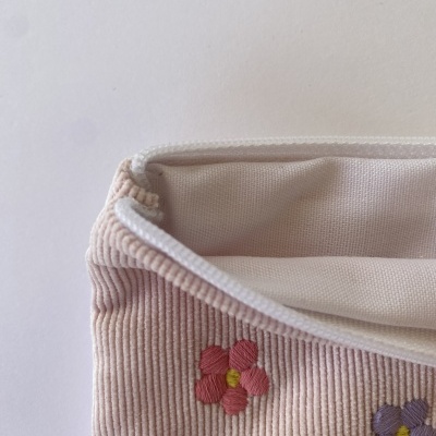 Estojo rosa com flores bordadas e interior creme