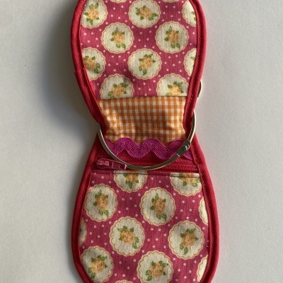 Estojo florido em tecido rosa com interior xadrez e fecho metálico