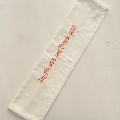 Estojo branco de tecido com frase bordada 'Say please and thank you!' em vermelho