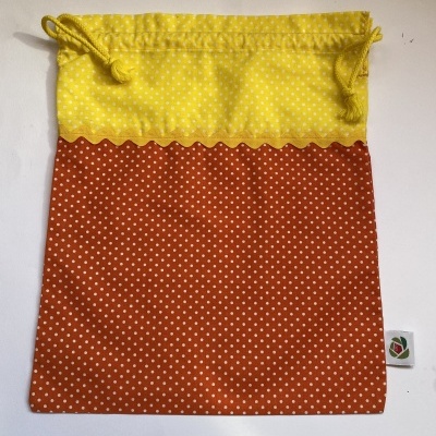 Saco de tecido amarelo e laranja com pontos brancos e cordão