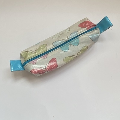 Estojo bege com borboletas coloridas e fecho azul