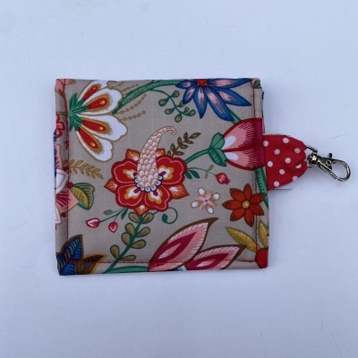 Carteira pequena em tecido com padrão floral e fecho metálico