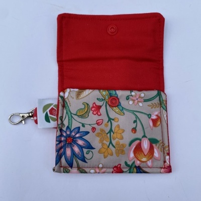 Estojo vermelho com padrão floral colorido e mosquetão