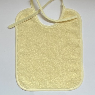 Babete amarelo de tecido com tiras para amarrar