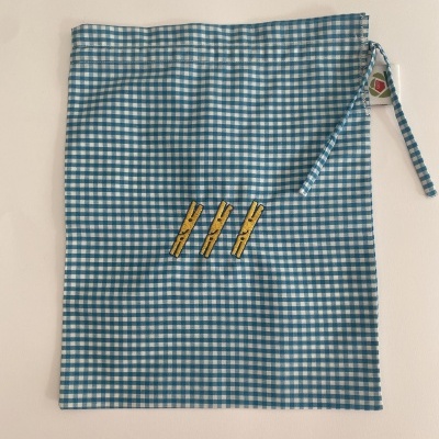 Saco de tecido xadrez azul e branco com bordado de pregadores amarelos