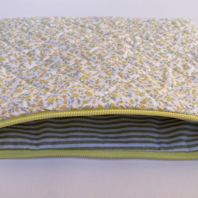 Bolsa acolchoada com padrão floral e interior às riscas