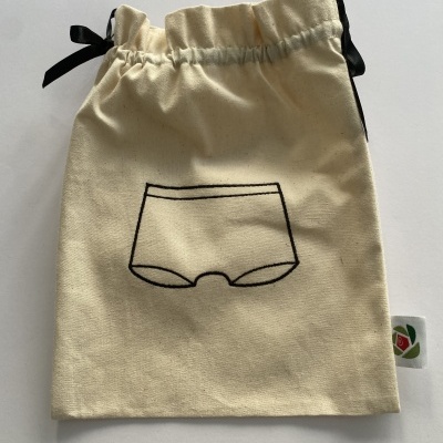 Saco de tecido bege com cordão preto e desenho de cueca