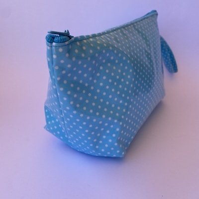 Bolsa azul claro com pontos brancos e fecho de correr