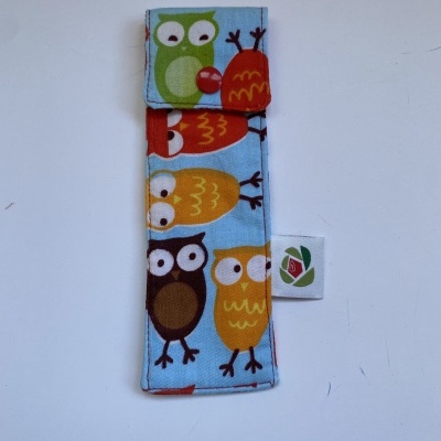 Estojos em tecido com padrão colorido de corujas sobre fundo azul claro