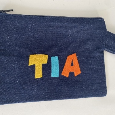 Necessaire azul escuro com letras coloridas TIA bordadas