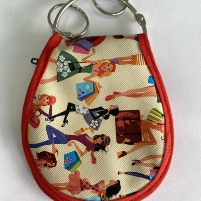 Carteira ou porta-moedas com estampado colorido de mulheres e borda vermelha.