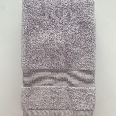 Toalha cinza claro dobrada com faixa listrada