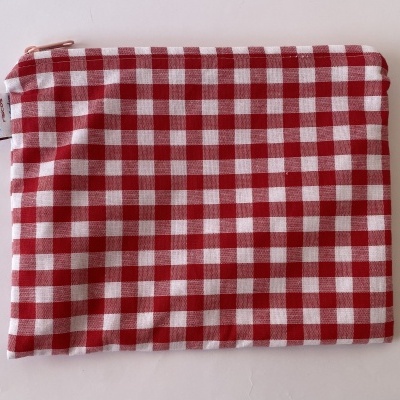 Bolsa xadrez vermelho e branco com fecho rosa e etiqueta atelier TRIGOS rascos