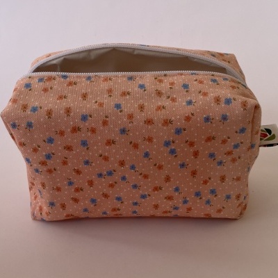 Necessaire rectangular em tecido cor de salmão com padrão de pequenas flores